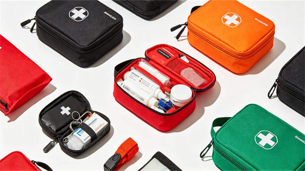 Multiple first aid kits in black red orange green for remote camp medical response