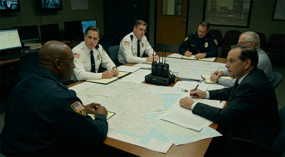 Emergency command center with maps and radios on table, government officials working around conference table, indoor operations center for government procurement