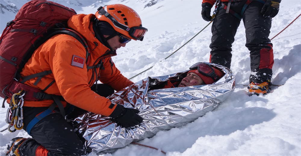 Wide view of avalanche victim wrapped in silver rescue bivvy bag on snow showing thermal protection after extrication Wide view of avalanche victim wrapped in silver rescue bivvy bag on snow showing thermal protection after extrication