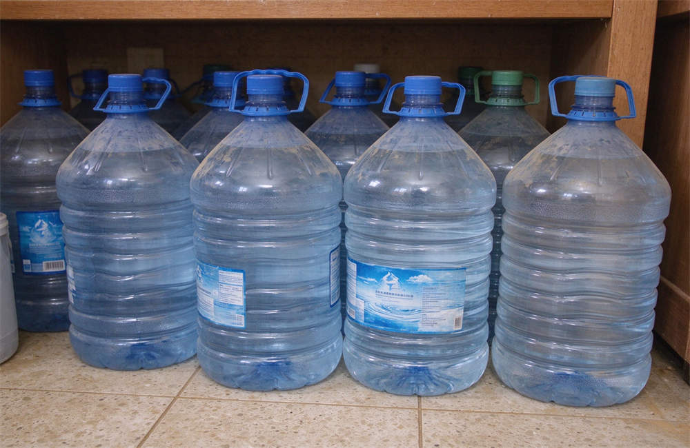 Emergency clean water storage jugs for sandstorm preparedness, bottled water supply for desert disaster relief Emergency clean water storage jugs for sandstorm preparedness, bottled water supply for desert disaster relief
